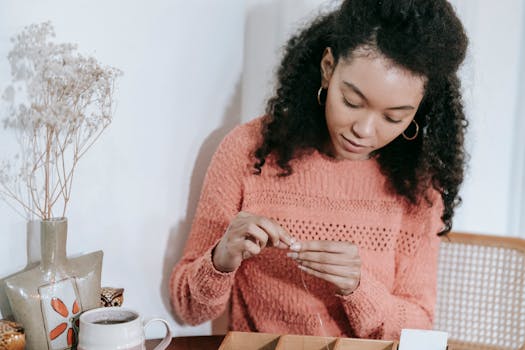 young woman crafting jewelry at a desk
